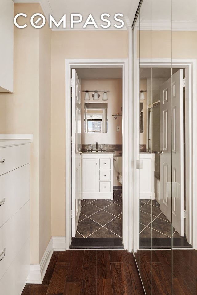 bathroom featuring toilet, ornamental molding, a stall shower, wood finished floors, and vanity