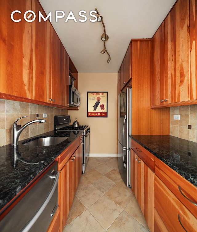 kitchen featuring brown cabinets, tasteful backsplash, appliances with stainless steel finishes, and a sink