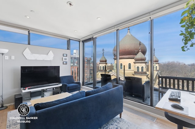 living room with expansive windows, baseboards, and wood finished floors