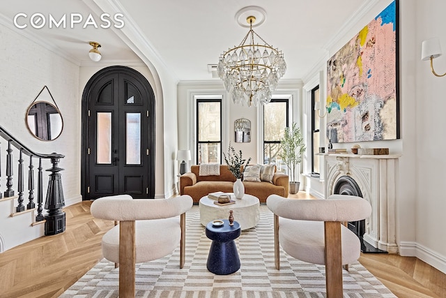 interior space featuring ornamental molding, stairway, arched walkways, an inviting chandelier, and baseboards