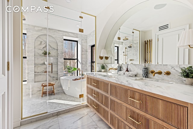 bathroom featuring marble finish floor, a stall shower, a sink, double vanity, and a soaking tub