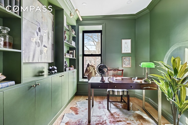 office space featuring baseboards, light wood-type flooring, and ornamental molding