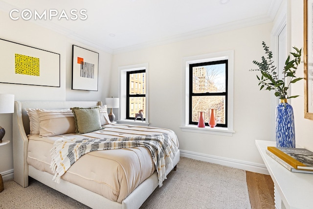 bedroom featuring crown molding, wood finished floors, and baseboards