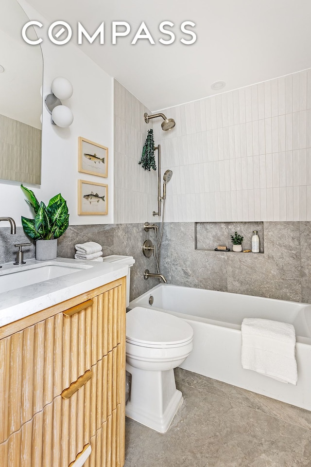 full bath with tile walls, vanity, toilet, and shower / bathing tub combination