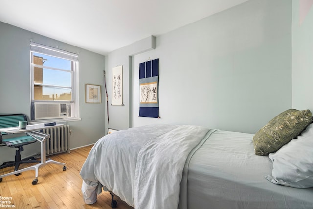 bedroom featuring radiator heating unit, cooling unit, and hardwood / wood-style floors