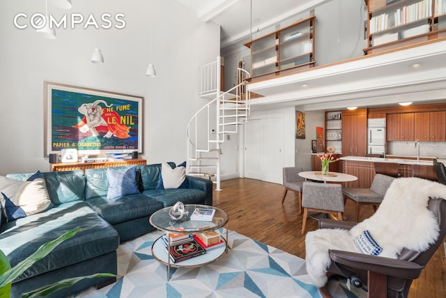 living area featuring stairway, a high ceiling, and wood finished floors