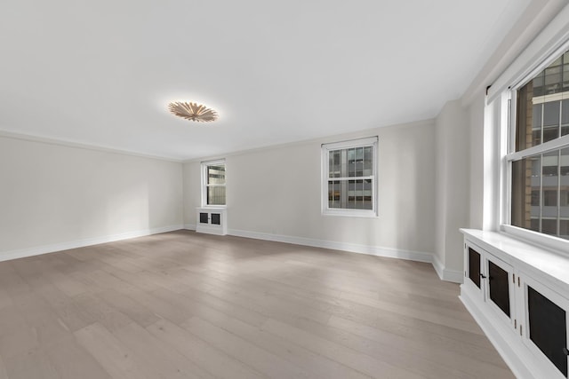 unfurnished living room featuring light wood-type flooring and baseboards