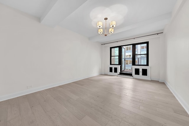 unfurnished room with baseboards, a chandelier, and light wood-style floors