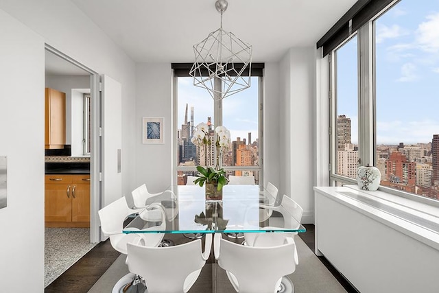 dining area with a chandelier, a city view, and dark wood-style floors