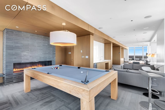 game room with a fireplace, a wall of windows, a sink, and pool table