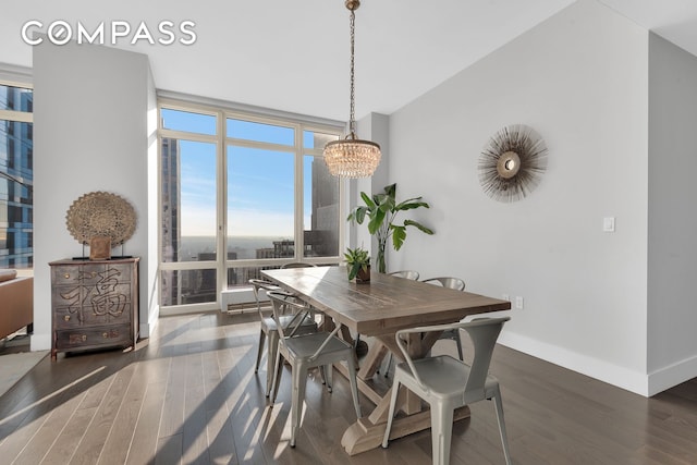 dining room featuring an inviting chandelier, expansive windows, baseboards, and wood finished floors