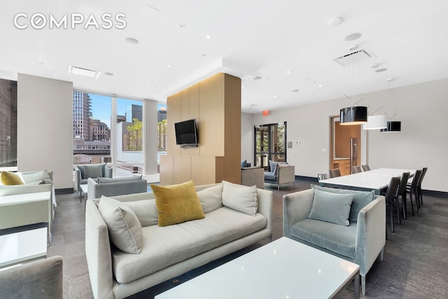 living area featuring baseboards, recessed lighting, and a healthy amount of sunlight