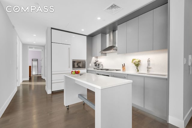 388 Bridge St Unit Ph50D, New York City, NY 11201 - kitchen with wall chimney range hood, modern cabinets, a sink, gas stovetop, and dark wood-style floors