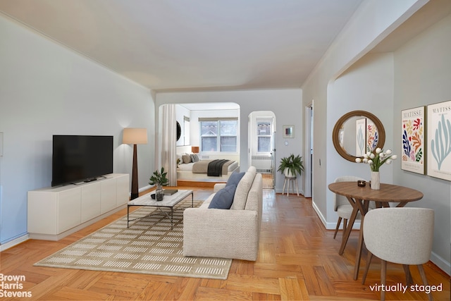 living area featuring arched walkways and baseboards