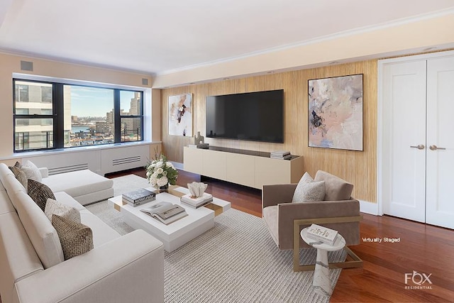 living area featuring visible vents, ornamental molding, and wood finished floors