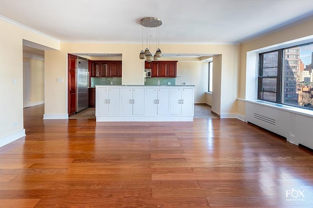 510 E 86th St Unit 14C, New York City, NY 10028 - kitchen with stainless steel appliances, wood finished floors, crown molding, decorative light fixtures, and baseboards