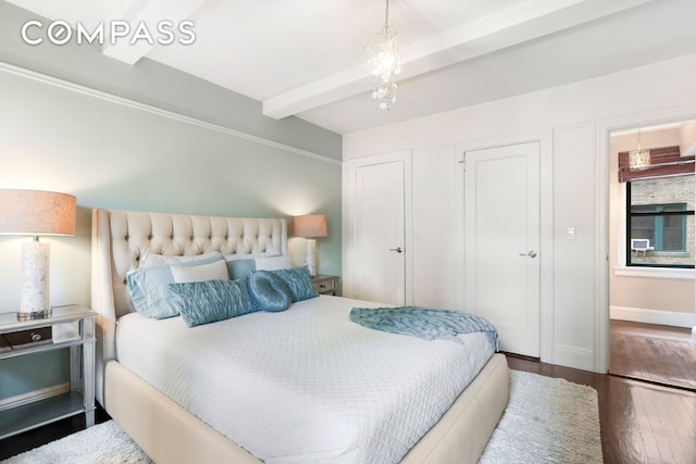 bedroom featuring beam ceiling and wood finished floors