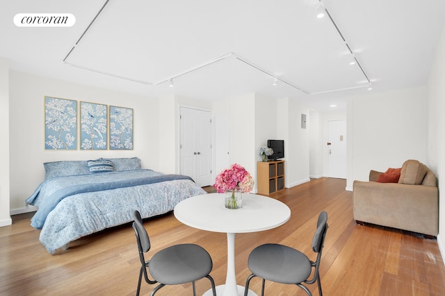 bedroom featuring track lighting, light wood-style floors, and visible vents