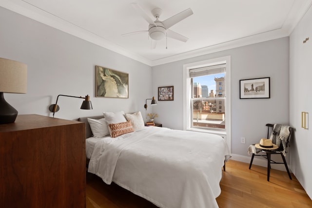 bedroom featuring ornamental molding, ceiling fan, baseboards, and wood finished floors