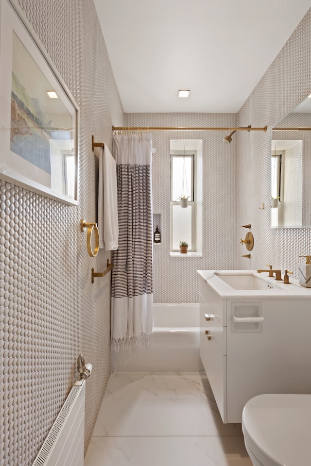 bathroom with marble finish floor, vanity, toilet, and shower / bathtub combination with curtain