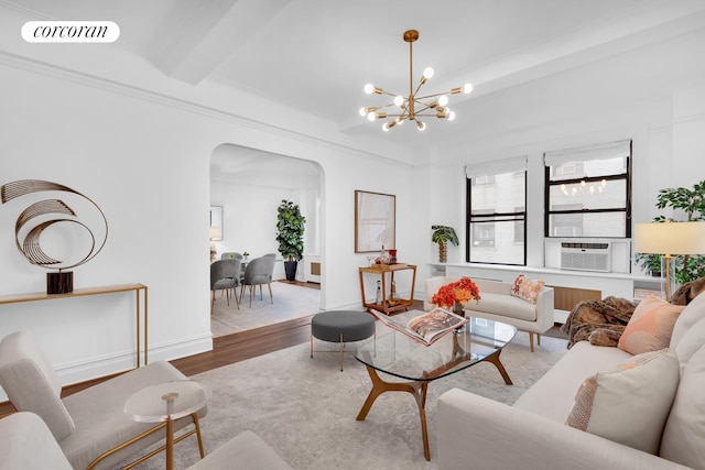 living area with arched walkways, cooling unit, a notable chandelier, wood finished floors, and visible vents