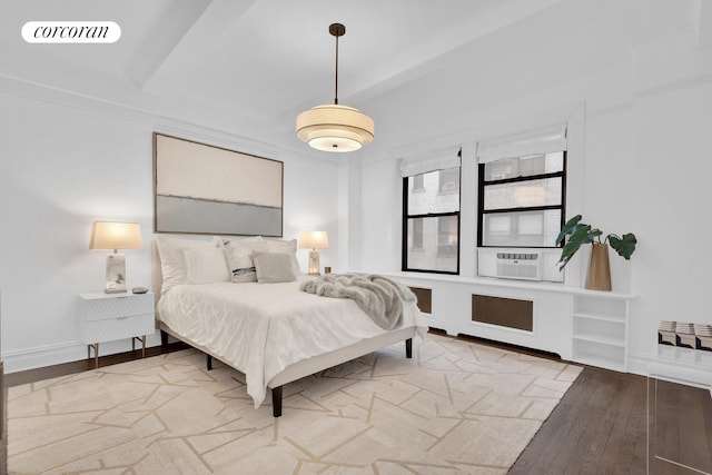 bedroom featuring cooling unit, visible vents, baseboards, and wood finished floors