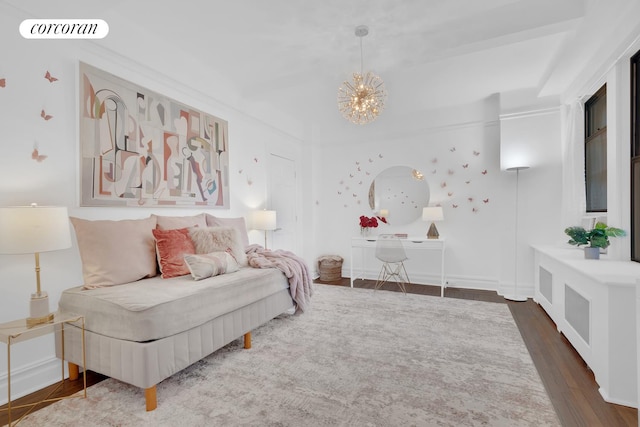 bedroom with baseboards, wood finished floors, visible vents, and a notable chandelier