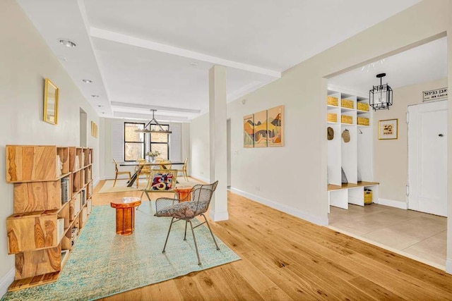 interior space with baseboards, light wood finished floors, and an inviting chandelier