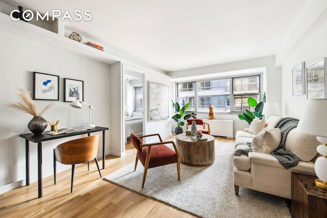 living area featuring radiator heating unit, wood finished floors, and baseboards