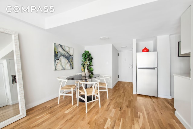 dining room with light wood-style flooring and baseboards