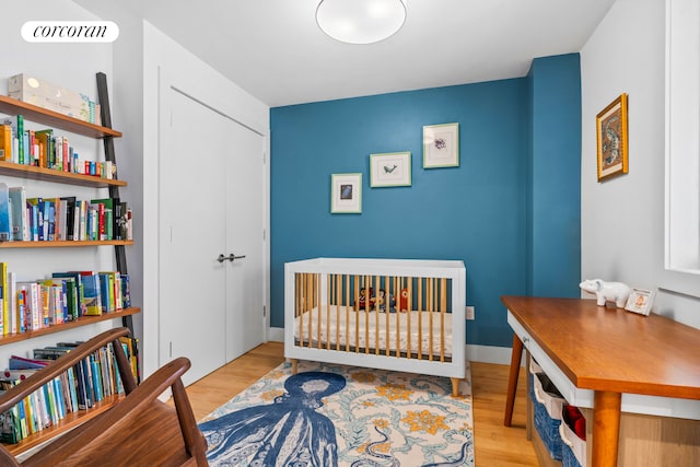 bedroom featuring a closet, light wood-type flooring, and baseboards