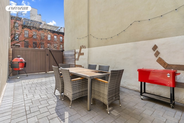 view of patio / terrace with a gate, outdoor dining area, and fence