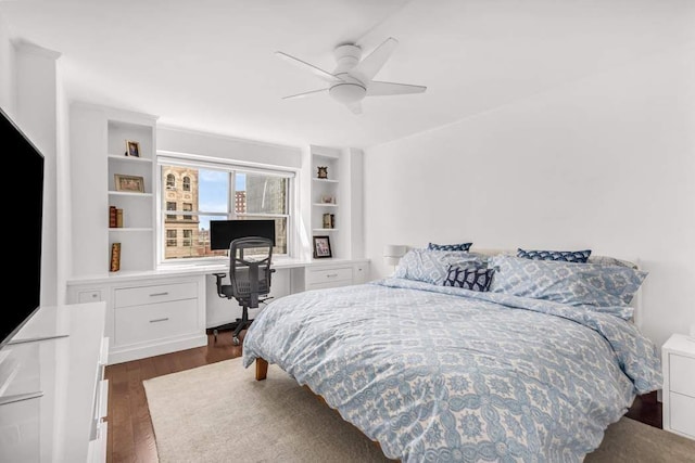 bedroom with a ceiling fan, dark wood-style flooring, and built in study area