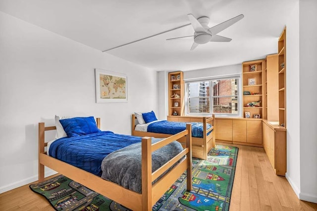 bedroom featuring baseboards, ceiling fan, and light wood finished floors