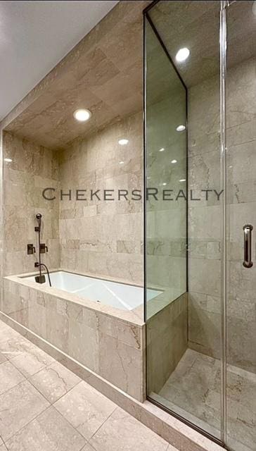 bathroom with tiled bath and a stall shower