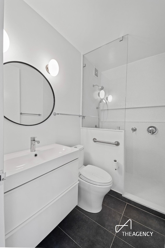 bathroom featuring vanity, walk in shower, tile patterned flooring, and toilet