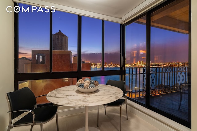 sunroom featuring a view of city and a water view