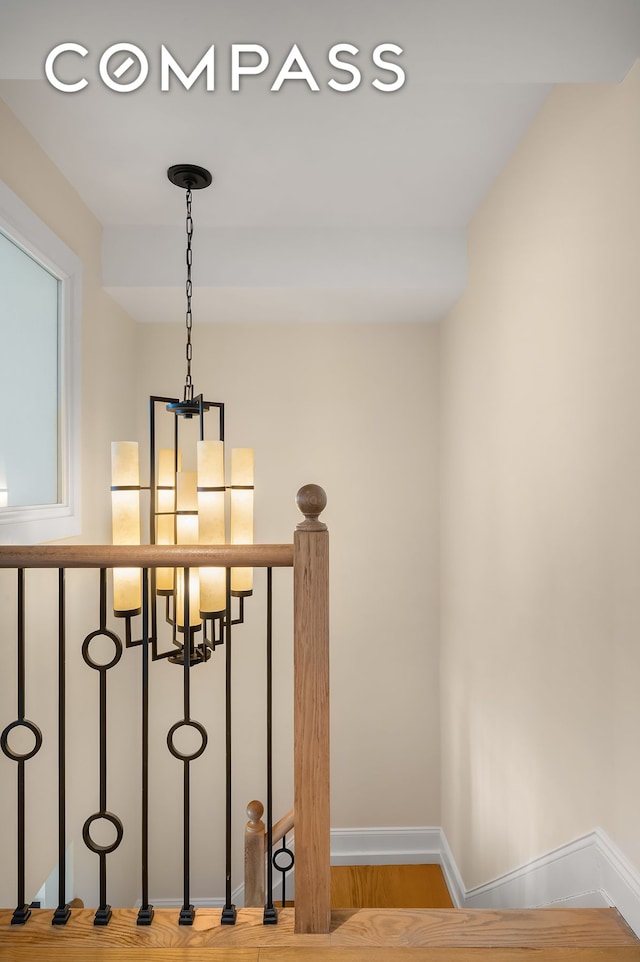 interior space with baseboards, a chandelier, and wood finished floors
