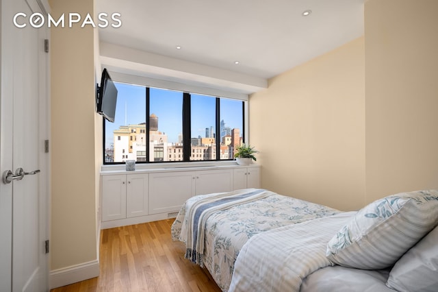 bedroom with recessed lighting, light wood-type flooring, and baseboards