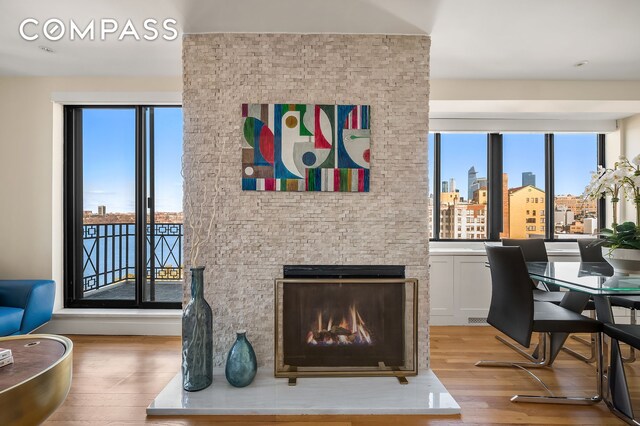 office space featuring plenty of natural light, a lit fireplace, light wood-type flooring, and a city view