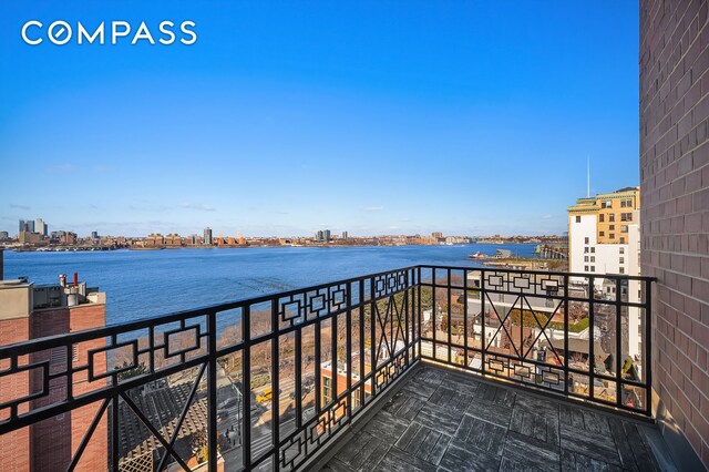 balcony with a water view and a view of city