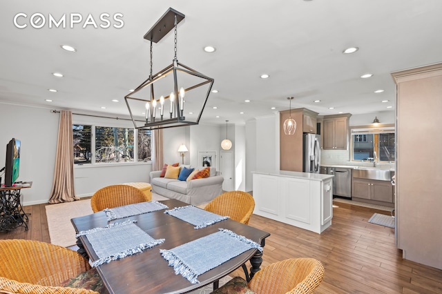 dining space with recessed lighting, light wood-type flooring, baseboards, and crown molding