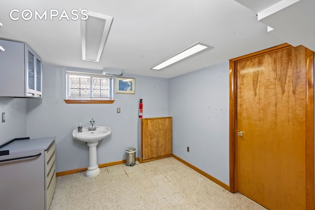 bathroom with tile patterned floors, baseboards, and a sink