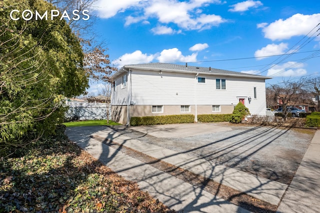 rear view of property featuring fence