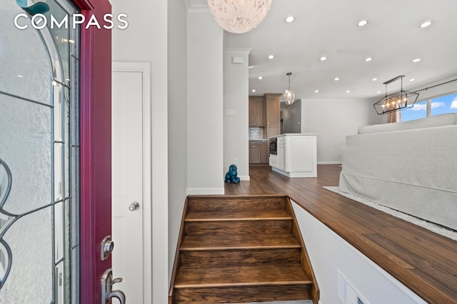 staircase with a chandelier, recessed lighting, baseboards, and wood finished floors