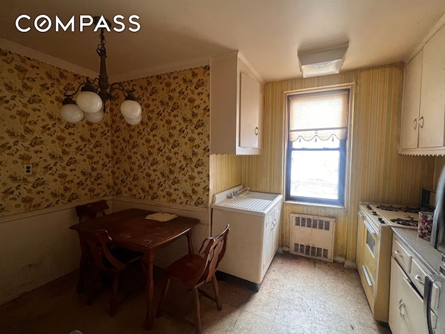 interior space with a sink, radiator, wainscoting, wallpapered walls, and white range with gas stovetop