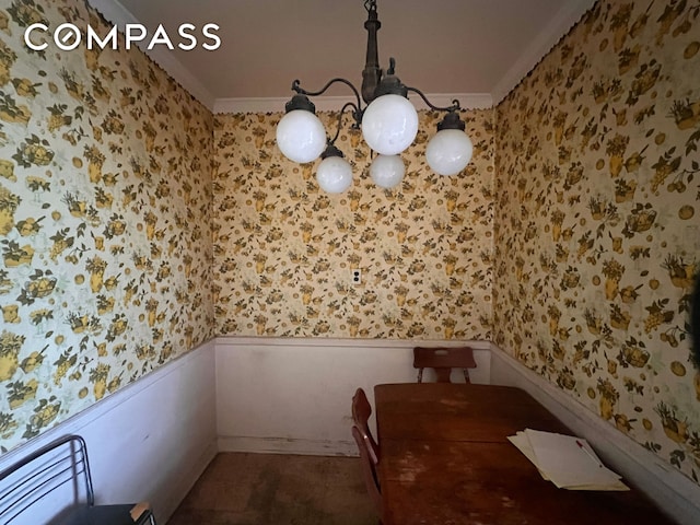 dining area with crown molding, wainscoting, and wallpapered walls