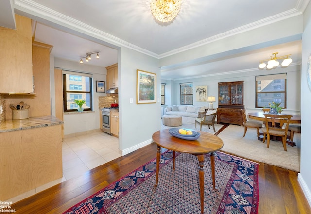 interior space with a chandelier, light wood-type flooring, and crown molding