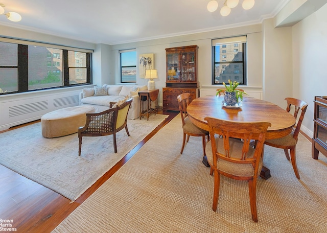 dining room featuring light wood-style flooring and crown molding