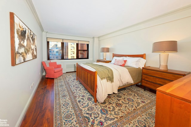 bedroom featuring ornamental molding, baseboards, and wood finished floors